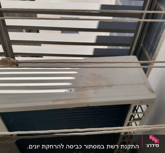 חוטים מתוחים מעל מזגן חיצוני במרפסת